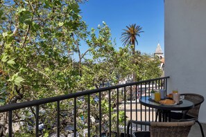 A balcony with a table set for breakfast, including croissants, juice, and coffee. - Apartment Riva ,city center (Makarska)