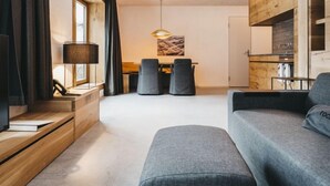 Una sala de estar moderna con un sofá, una mesa de comedor con sillas, una lámpara y un mueble de madera.