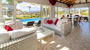 A spacious living area with a pool view, wicker furniture, and a dining area with outdoor seating. - Septimo Cielo by Interhome (Calpe/Calp)