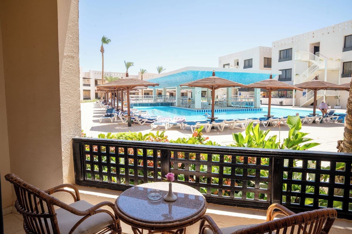 Deluxe King Pool View | Premium bedding, in-room safe, blackout drapes, WiFi