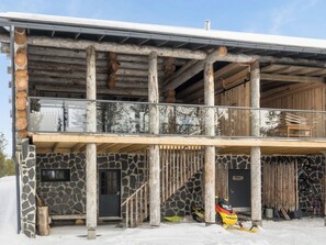 Un edificio de dos pisos con fachada de piedra, vigas de madera y un balcón.