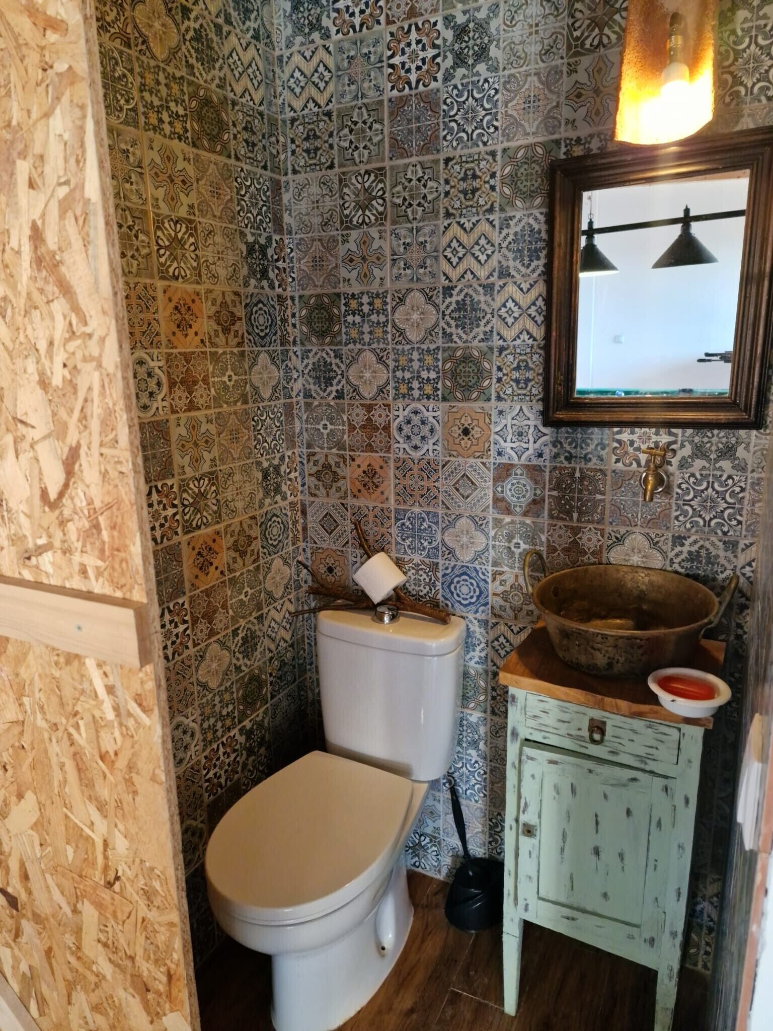 Un bagno con un water, un lavandino e uno specchio.