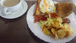 Prato de café da manhã com torradas, ovos, bacon e batatas.
