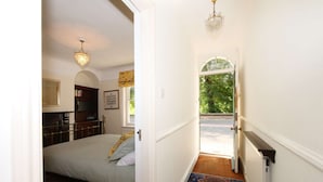 A bedroom with a bed, a dresser, a mirror, and a chandelier. - Stodham House Quirky Central Townhouse, 4 beds sleeps up to 9 (York)