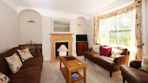 A living room with a fireplace, a television, and a sofa. - Stodham House Quirky Central Townhouse, 4 beds sleeps up to 9 (York)