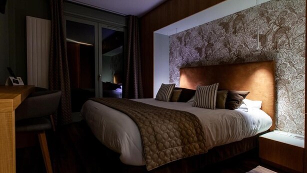 Un dormitorio con una cama grande, un escritorio y una ventana con vistas.