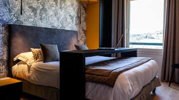 A bedroom with a bed, a desk, and a laptop.