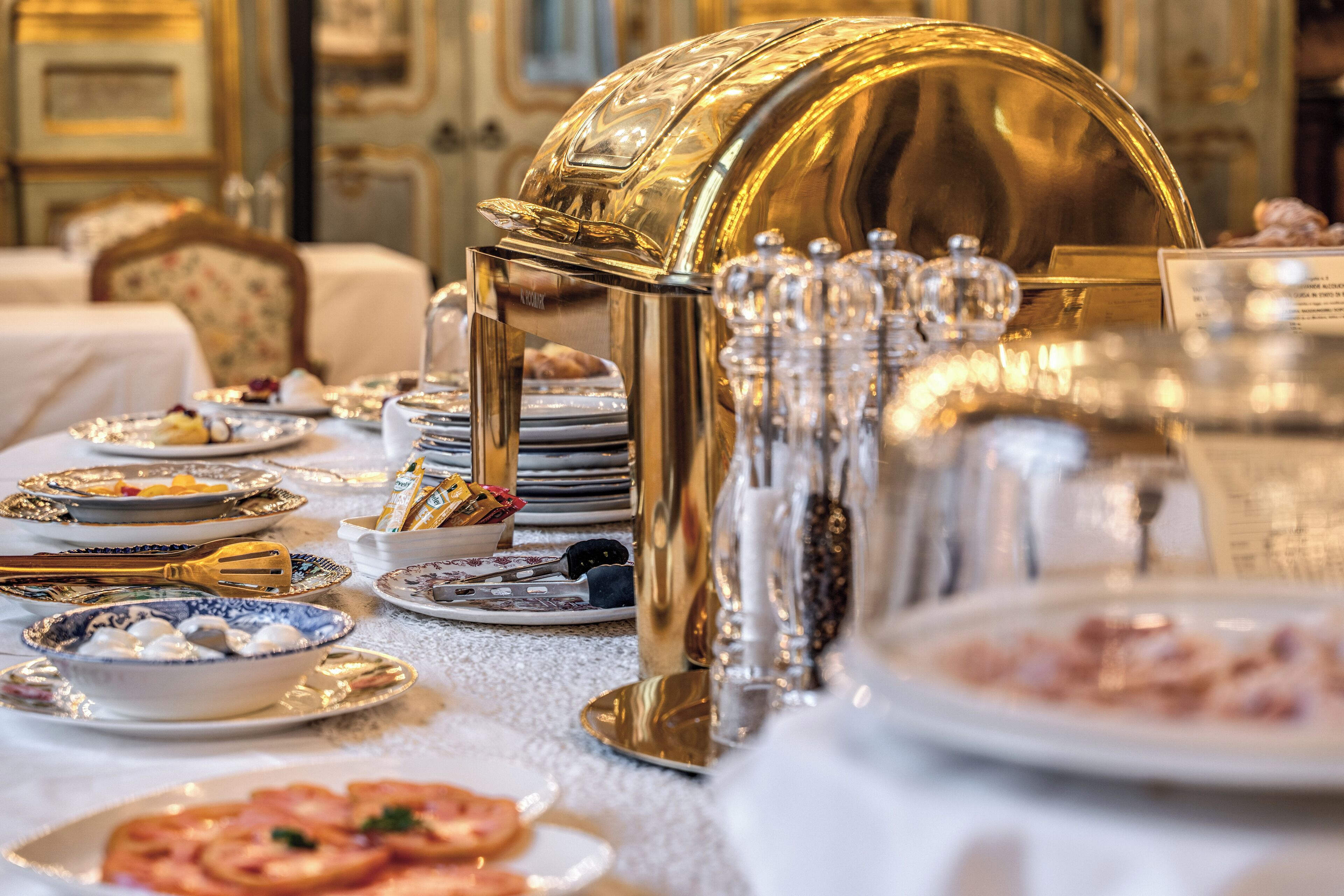 A buffet setup with various dishes and a golden serving station.