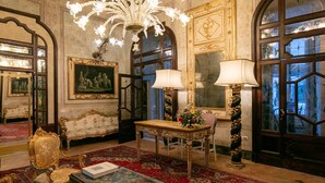 A luxurious room with ornate furniture, a chandelier, and a large mirror. - Palazzo Doria Napoli (Naples)