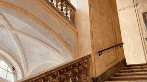 A grand staircase with ornate balustrades, leading to a high ceiling with arched windows and a vaulted ceiling. - Palazzo Doria Napoli (Naples)