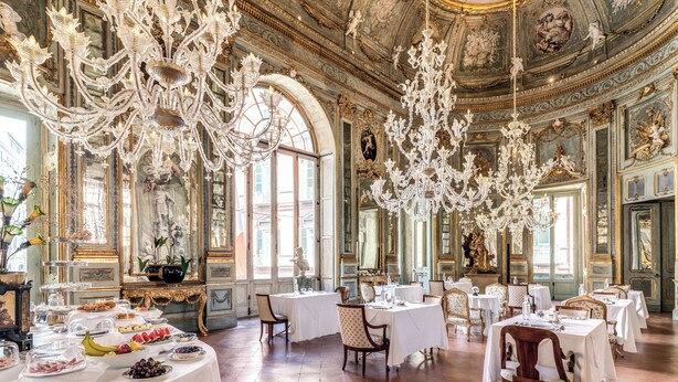 A grand dining hall with ornate chandeliers, classical ceiling frescoes, and a series of tables set for a meal. - Palazzo Doria Napoli (Naples)
