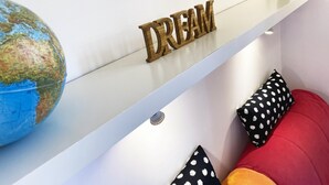 A globe, a wooden sign with the word "DREAM," and two cactus-shaped vases on a shelf.