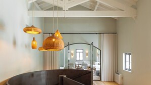 Una habitación amplia con techo alto, suelo de madera y una gran estructura circular negra.