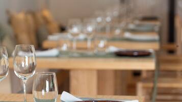 Varias mesas con copas de vino vacías y platos, indicando un comedor en un restaurante.