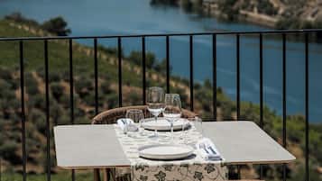 A table set for two with a view of a lake and hills in the background.