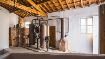 Un interior rústico con vigas de madera a la vista, paredes de ladrillo y equipo de elaboración industrial.