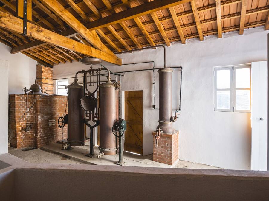 Un intérieur rustique avec des poutres apparentes, des murs en briques et du matériel de brassage industriel.