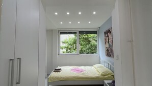 Une chambre à coucher avec un lit, une fenêtre et une armoire.