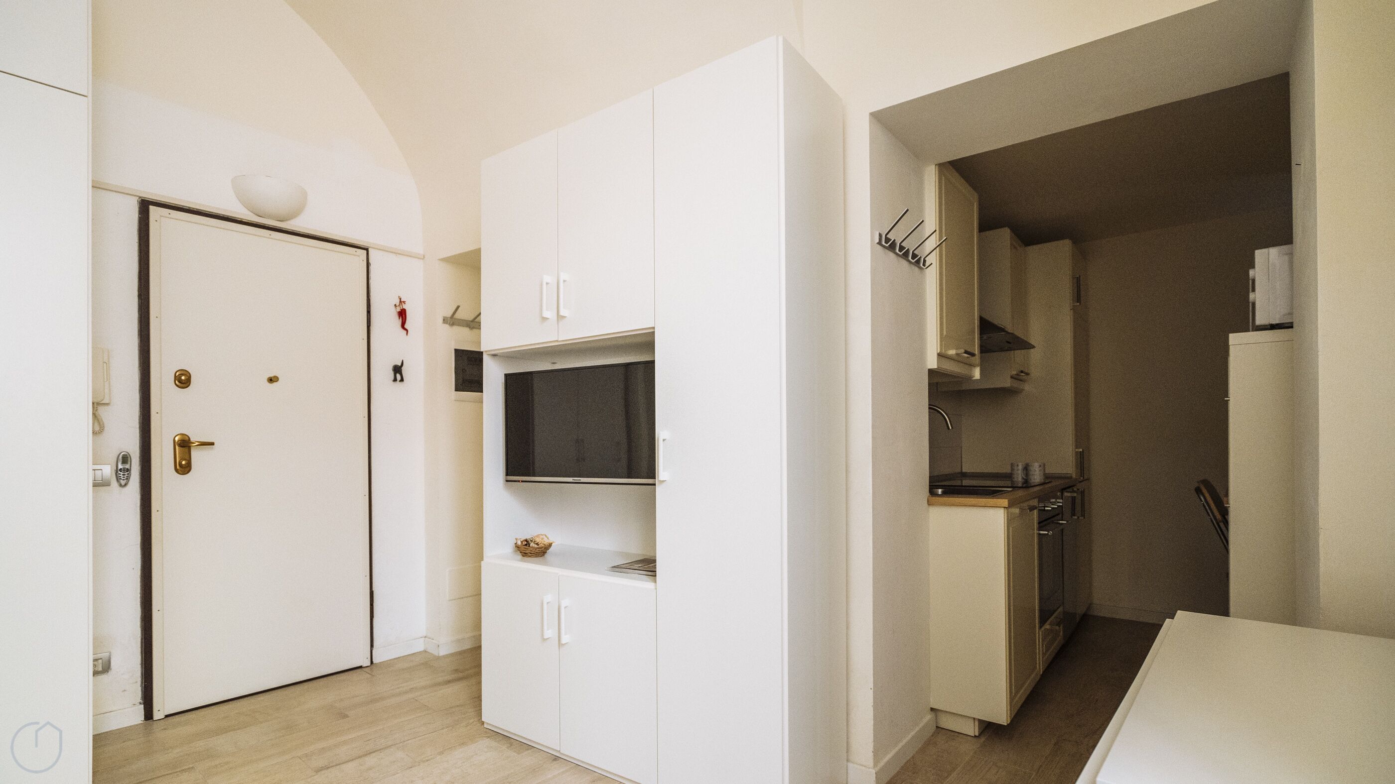 A compact kitchen with white cabinetry, a built-in microwave, and a small countertop.