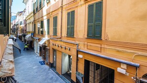 Une rue étroite, bordée de bâtiments des deux côtés, avec des devantures de magasins et une marquise bien visible.