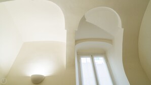 Une pièce avec de hauts plafonds et des fenêtres en arc de cercle.