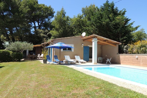 A small building with a pool, surrounded by trees and a grassy area with lounge chairs. - Holiday Home in Buisson with Private Pool (Buisson)