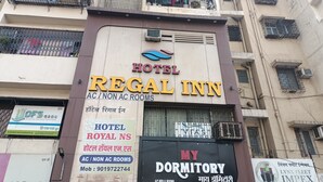 A building with multiple signs advertising various accommodations, including Hotel Regal Inn, Hotel Royal NS, and My Dormitory. - Hotel Regal Inn (Mumbai)