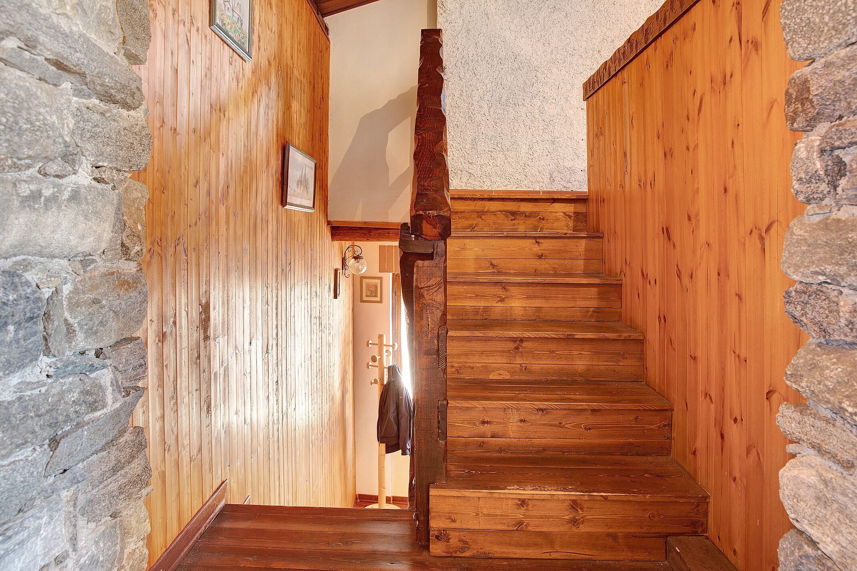 Un escalier en bois, avec des murs en pierre et un plancher en bois.