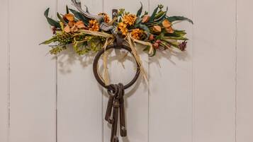 Ein an der Wand befestigter Schlüsselring mit Blumenarrangement und rustikalem Anhänger.
