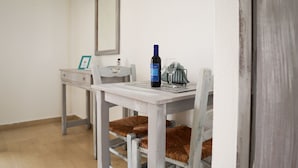 Ein Essbereich mit Tisch, Stühlen, einer Weinflasche und einem Glas.