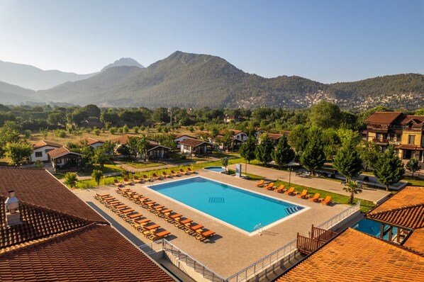 Relax by the pool surrounded by mountains and lounge chairs.