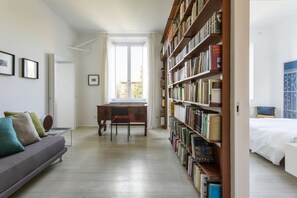 A room with a sofa, a desk, a bookshelf, and a bed. - GuestHost - Large and bright 200sqm apartment, able to accommodate up to 7 people, located on the 3rd floor with elevator (not suitable for disabled people) of a building dating back to the 19th century. The property overlooks Piazza Fanti's garden and i (Roma)