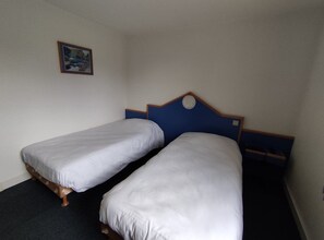 Habitación básica con 2 camas individuales | Espacio para trabajar con laptop, wifi gratis y ropa de cama 