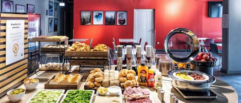 Un bufé de desayuno con diversas opciones de comida y una estación de café.
