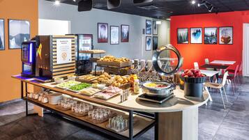 Ein reichhaltiges Frühstücksbuffet mit verschiedenen Speisen und einer Kaffeemaschine.