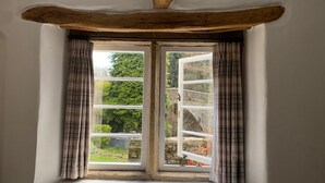 A window with a wooden beam above it, flanked by curtains. - Beautiful Peak District Cottage With Hot Tub (Hope Valley)