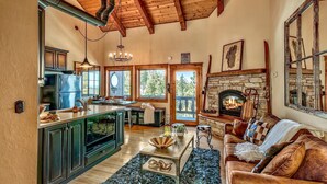 A spacious living area with a kitchen, a fireplace, and a large window overlooking a deck. - Mv8  lakeview across from Heavenly (Stateline)