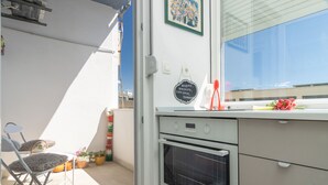 A kitchen with a white oven, a window, and a door with a welcome sign. - Mina Apartment (Split)