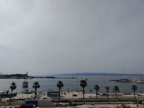 A coastal marina with boats, palm trees, and a promenade. - Mina Apartment (Split)