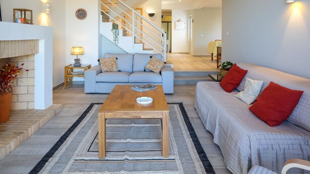 Ein modernes Wohnzimmer mit einer Couch, einem Couchtisch und einer Treppe, die in einen anderen Raum führt.