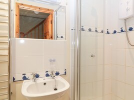 Un baño con lavamanos, espejo y ducha.