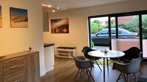 A modern room with a dining area, a wooden cabinet, and artwork on the walls. - Beautiful vacation home on Rügen (Wiek)