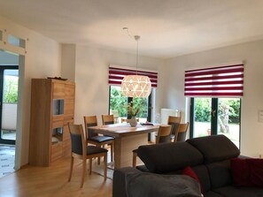 A modern kitchen with a dining area, wooden cabinets, and a central island.