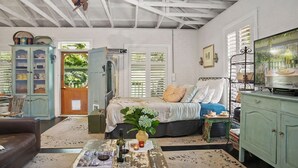 A bedroom with a bed, a dresser, a television, and a cabinet.