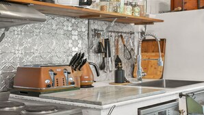 A kitchen with a toaster, a knife block, and a sink. - Saint Eloi - Le studio (Bowral)