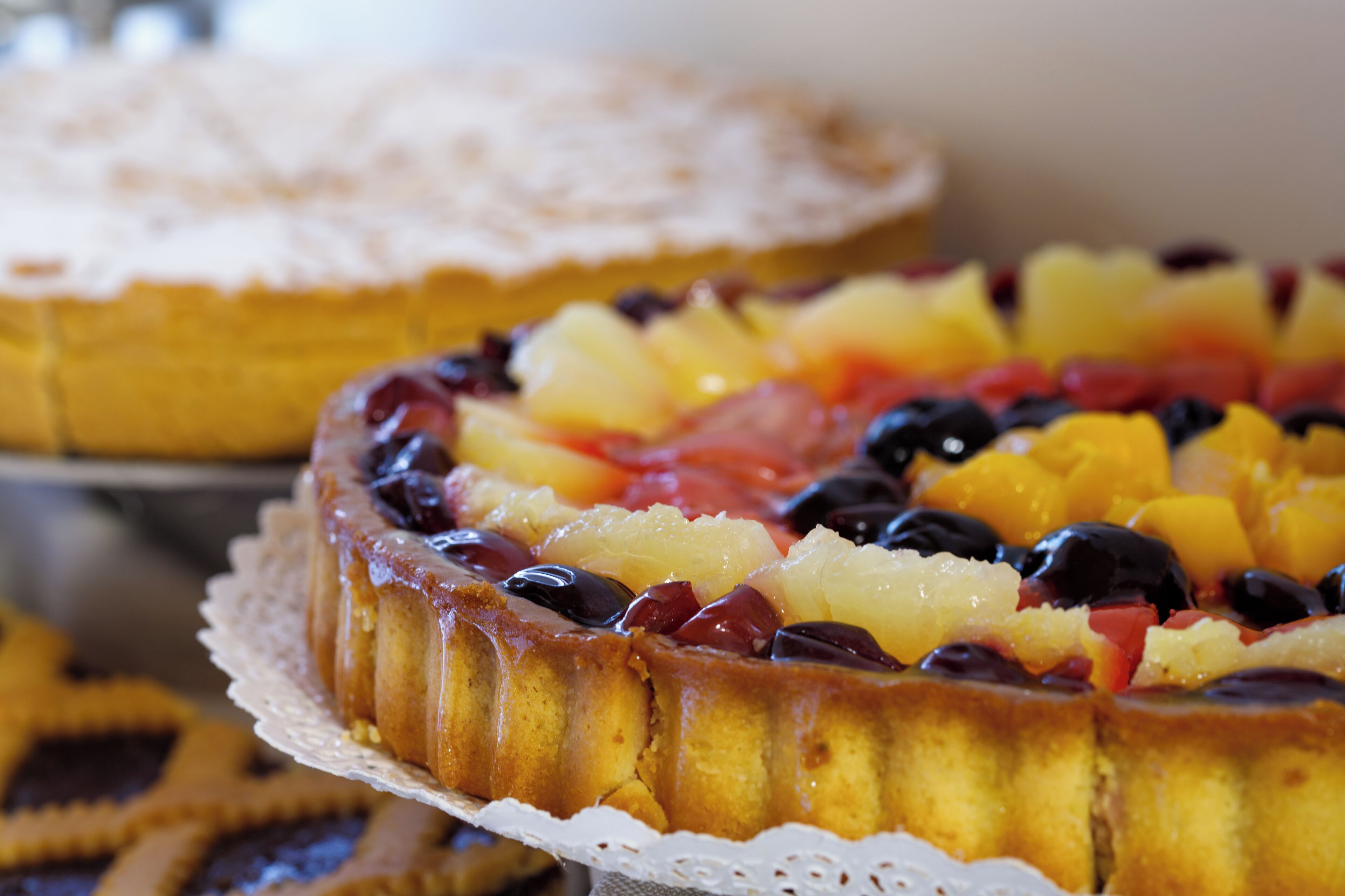 Un gâteau rond, à la croûte dorée, posé sur une nappe en dentelle blanche.
