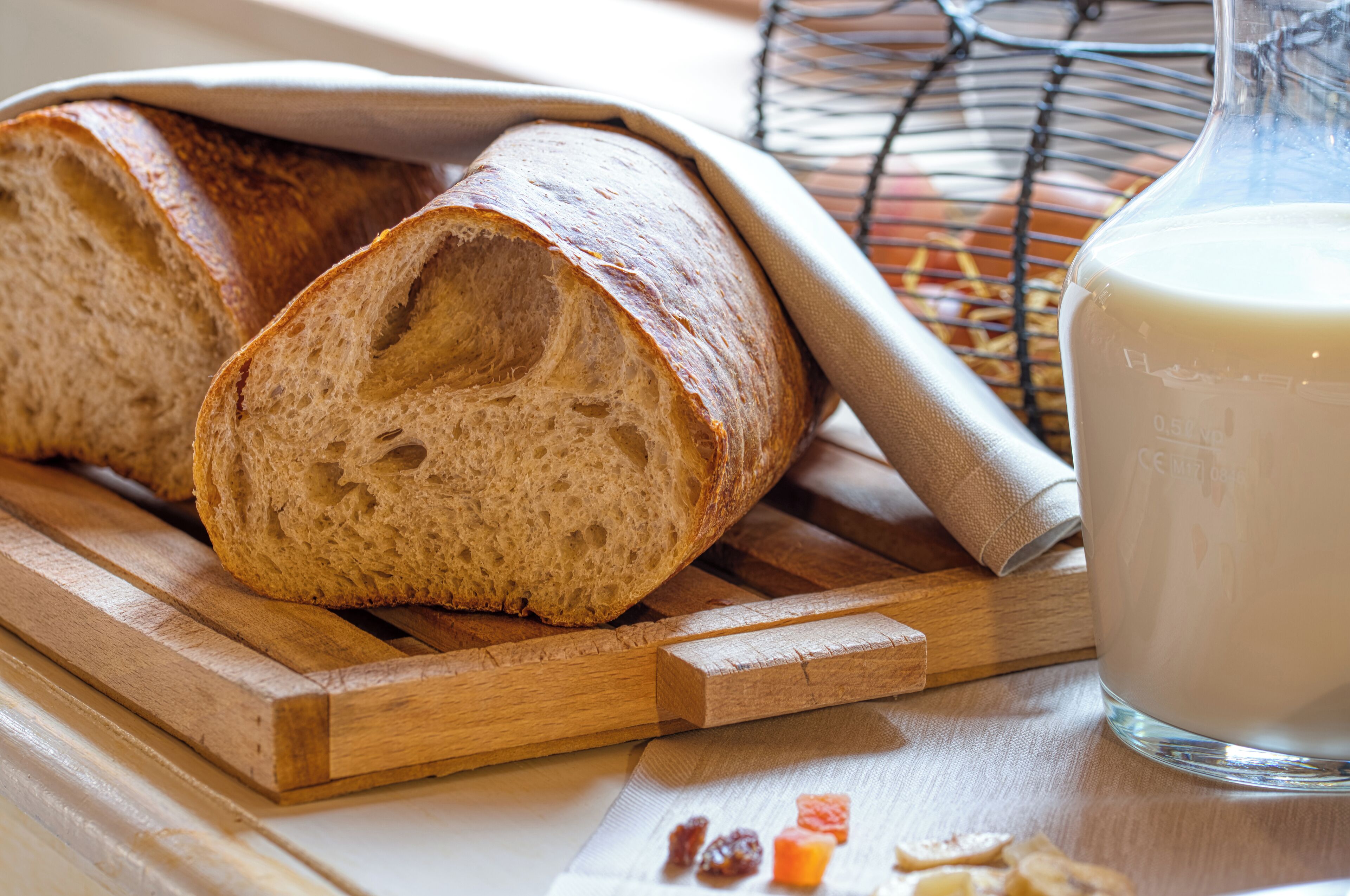 Een brood en een glazen fles op een houten ondergrond.