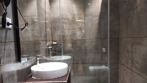 A modern bathroom with a glass-enclosed shower, a wooden vanity, and a white sink. - Mastiff Hotel Dalhousie (Dalhousie)