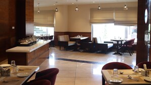 A restaurant with a central island, multiple tables, and chairs. - Mastiff Hotel Dalhousie (Dalhousie)