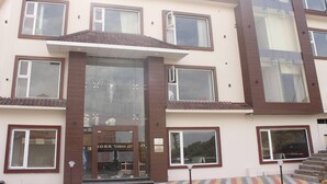 A multi-story hotel with a central entrance, large windows, and a visible sign for the "Let Homelab Hotel." - Mastiff Hotel Dalhousie (Dalhousie)